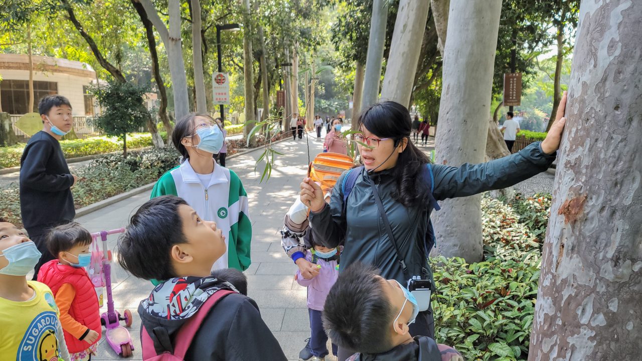 A volunteer educating children about plants